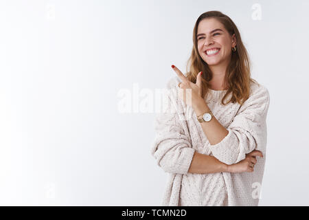 Hilarious scene woman cannot stop laugh. Carefree attractive joyful charming girl turning sideways pointing left corner smiling amused having fun watc Stock Photo