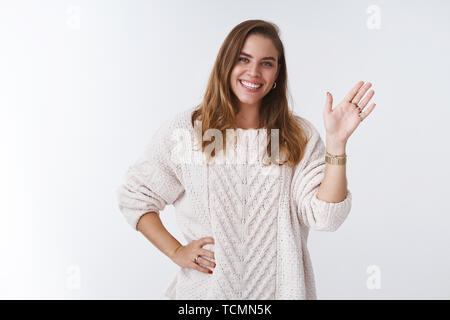 Friendly outgoing good-looking female coworker getting know newbies smiling broadly waving hand hello hi gesture welcoming members expressing positive Stock Photo