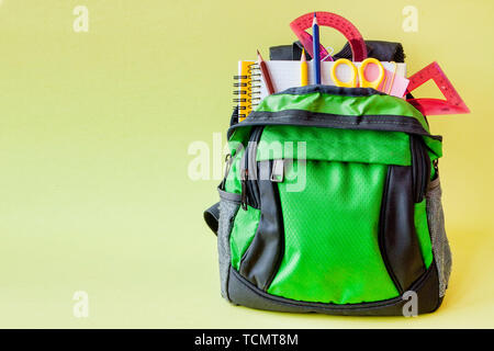 Composition with backpack and school stationery on yellow background. Stock Photo