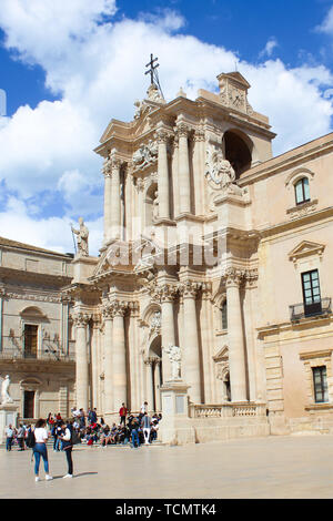 Syracuse, Italy - Apr 10th 2019: Amazing Roman Catholic Cathedral of Syracuse in Sicily with tourists on adjacent square. The religious temple is part of UNESCO World Heritage. Popular tourist spot. Stock Photo