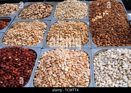 Variety of nuts in containers exposed in the market Stock Photo