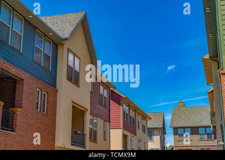 Houses with balcony and shiny windows against blue sky on a sunny day Stock Photo
