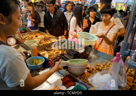 TAIPEI, TAIWAN - JULY 13, 2013: Customers ordering Chinese street food consisting of braised beef and pork entrails in Taipei's Shilin Night Market, t Stock Photo