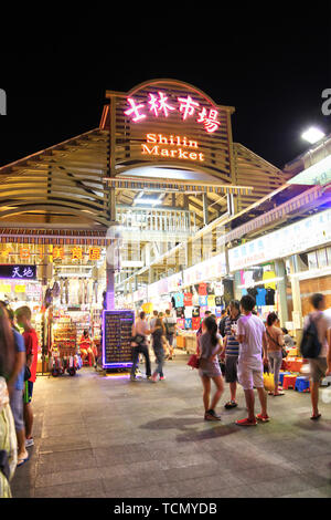 TAIPEI, TAIWAN - July 14, 2013: Crowd mingle at the entrance of Shilin Night Market in the Shilin District of Taipei. Shilin Market is the most popula Stock Photo