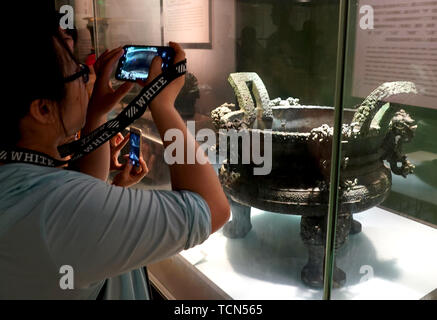 Zhengzhou, China's Henan Province. 9th June, 2019. A visitor takes a picture of a bronzeware displayed at Henan Museum in Zhengzhou, capital of central China's Henan Province, June 9, 2019. Credit: Li An/Xinhua/Alamy Live News Stock Photo