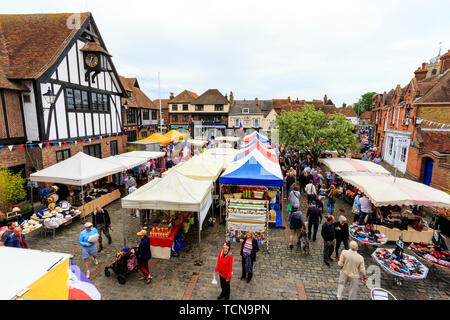 Le Weekend event French market at Sandwich, England. High angle view. French market stalls in town square with many people. Medieval guildhall on left and medieval houses in the background. Stock Photo