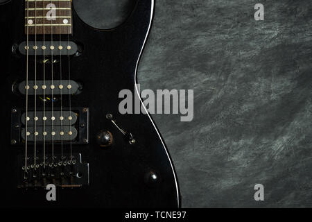 Black electric guitar on black cement floor. Top view and copy space for text. Concept of rock music. Stock Photo