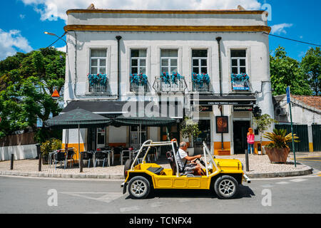 Azeitao, Portugal - June 7, 2019: Yellow buggy parked in front of a cafe in the charming village of Azeitao, Portugal, famous for its wines and cheese Stock Photo