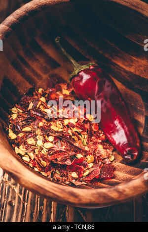 Flakes of ground red chili pepper in wooden bowl Stock Photo