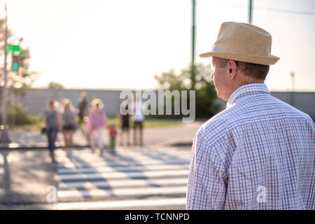 Mature spanish man waiting to cross street