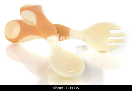 Small beige spoon and fork for babies isolated on white Stock Photo
