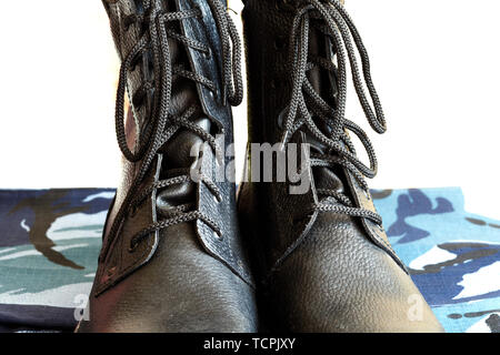 Shoelaces in black army boots close-up on white background. Lacing Stock Photo