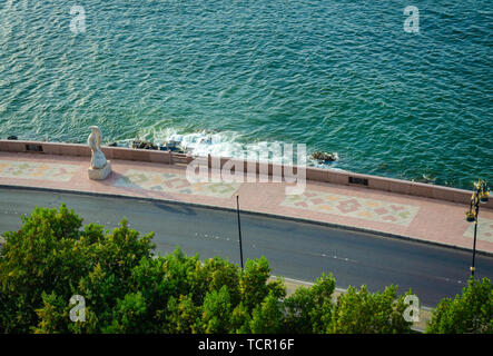 Coastal Road with pattern tiled pavement and a fish statue from Muttrah, Muscat, Oman. Stock Photo