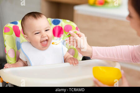 Mother giving healthy food to her adorable baby child Stock Photo