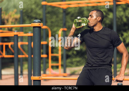 African Man Drinking Water when Resting After Training Stock Photo