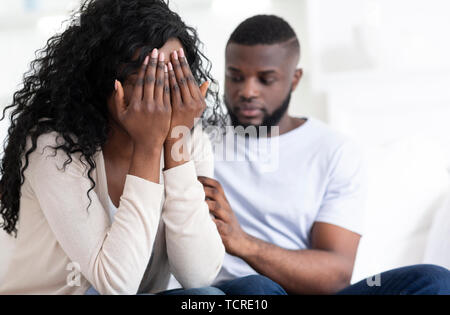 Loving man soothing crying woman, apologizing after quarrel Stock Photo