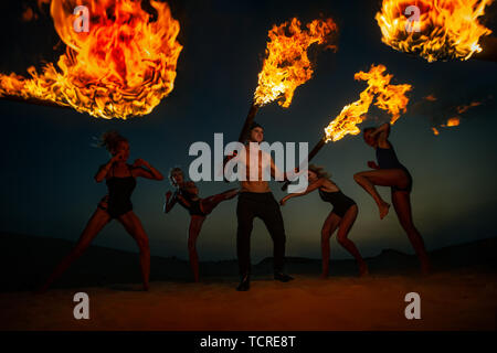 Women are fighting with man in dunes Stock Photo