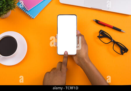Woman using blank smartphone on orange background Stock Photo
