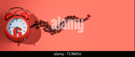 coffee beans in orange alarm clock on bright pink background Stock Photo