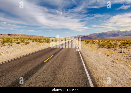 Road through a desert and mountains in California, USA Stock Photo