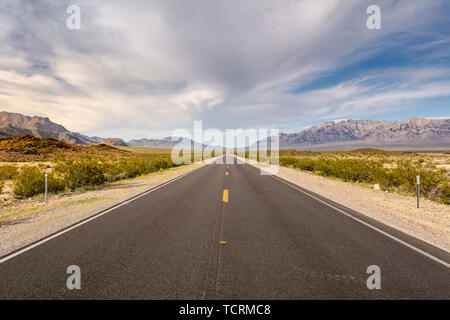 Road through a desert and mountains in California, USA Stock Photo