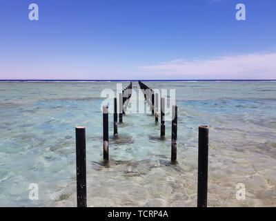 metal piles for pier in the sea. Clearly visible clear sea water and the blue sky on the horizon. space for text Stock Photo