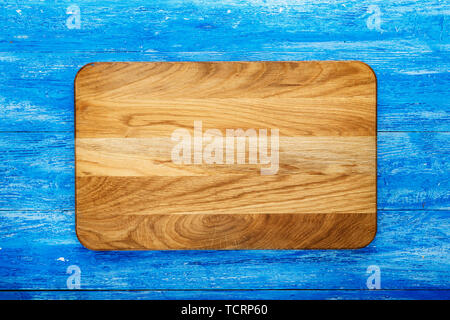 Rectangular wooden cutting board on a wooden background. space for text Stock Photo