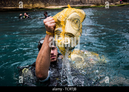 Calypso Dive Club member clears trash from the sea along Beirut's Corniche during the clean up day. Lebanese people came out to help with a National Beach Clean up Day spearheaded by the Lebanese Minister for Environment. Not only did they collect trash from their beaches at over 150 locations, teams of scuba divers also spent their day underwater, clearing up everyone's waste from the ocean floor. Beirut, Lebanon. Stock Photo