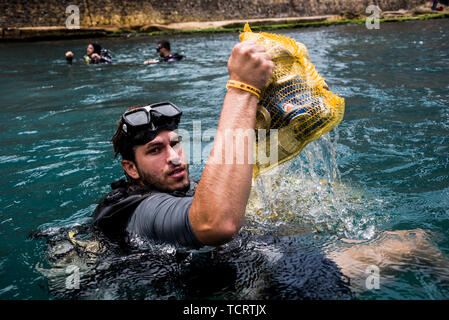 Calypso Dive Club member clears trash from the sea along Beirut's Corniche during the clean up day. Lebanese people came out to help with a National Beach Clean up Day spearheaded by the Lebanese Minister for Environment. Not only did they collect trash from their beaches at over 150 locations, teams of scuba divers also spent their day underwater, clearing up everyone's waste from the ocean floor. Beirut, Lebanon. Stock Photo