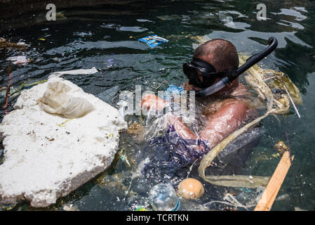 Calypso Dive Club member clears trash from the sea along Beirut's Corniche during the clean up day. Lebanese people came out to help with a National Beach Clean up Day spearheaded by the Lebanese Minister for Environment. Not only did they collect trash from their beaches at over 150 locations, teams of scuba divers also spent their day underwater, clearing up everyone's waste from the ocean floor. Beirut, Lebanon. Stock Photo