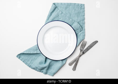 Table setting with empty plate, cutlery and linen textile isolated on white background, top view with copy space for text Stock Photo