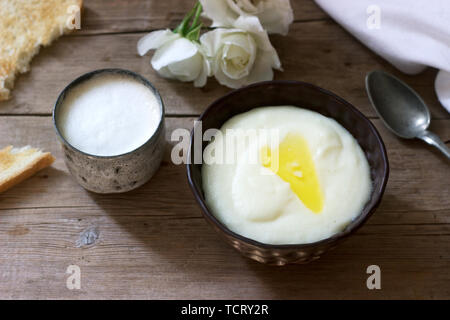 Homemade breakfast of semolina porridge, coffee with milk and toast on a wooden background. Rustic style, selective focus. Stock Photo