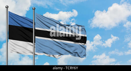 Botswana and Estonia flag waving in the wind against white cloudy blue ...