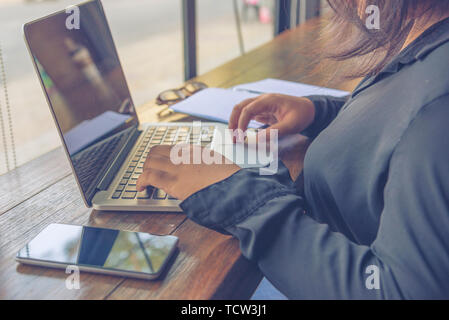 Close up of woman in black shirt using laptop Stock Photo