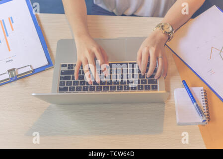 Top view of female hands typing on laptop keyboard Stock Photo