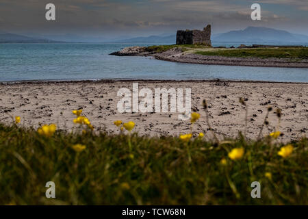 The desolate ruins of a large house or small castle on the coastline on the Ring of Kerry, Ireland on an overcast day Stock Photo