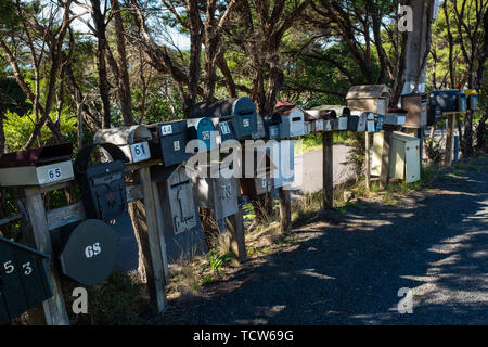 A row of various shaped and sized mail boxes by the side of the road in rural New Zealand, nobody in the image Stock Photo