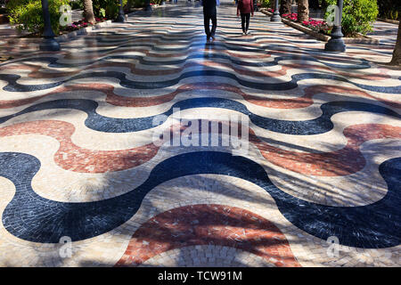 3D effect of wavy tiled paving along the Palm lined Esplanade in Alicante, Spain Stock Photo