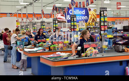 Staff at checkouts in B&M discount store ready to help customers Stock Photo