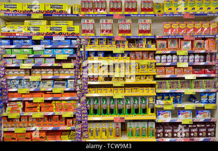 Multiple shelves full of a variety of sweets on display in store