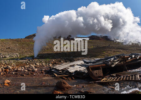 Emission of mineral natural thermal water, steam (steam-water mixture) from geological well in geothermal deposit area, geothermal power station Stock Photo