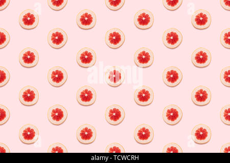 Grapefruit slices seamless pattern on pastel pink background. Minimal summer concept. Flat lay, trendy juicy color. Stock Photo