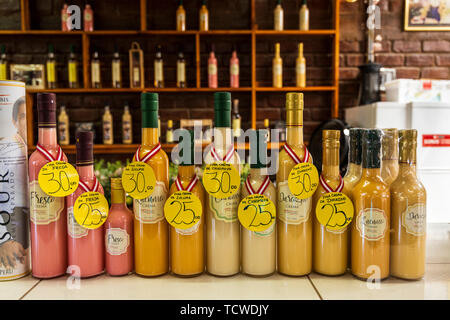 Bottles of various flavours of Pisco in the Tony Labis winery and pisco distillery in Huacachina, Peru, South America Stock Photo