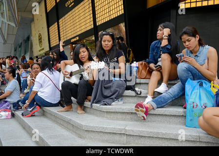 singapore - 2018.02.25: philippine maids spending time during their only free day on sunday on orchard road in front of ion shopping mall Stock Photo