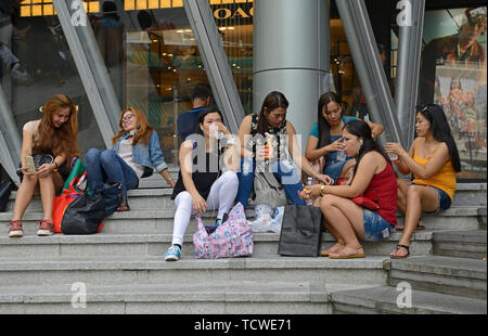 singapore - 2018.02.25: philippine maids spending time during their only free day on sunday on orchard road in front of ion shopping mall Stock Photo