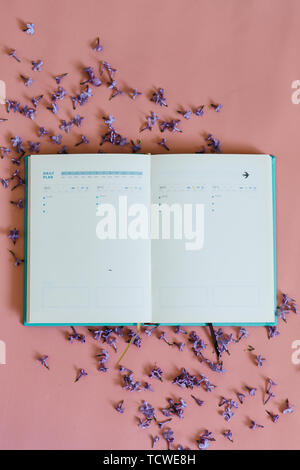 School notebook with lilac flowers on pink background Stock Photo