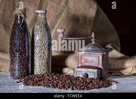 old coffee grinder and two glass bottles with different coffee beans Stock Photo