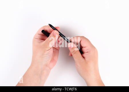The girl holds in hand a black eyeliner on a white background. Top view. Stock Photo