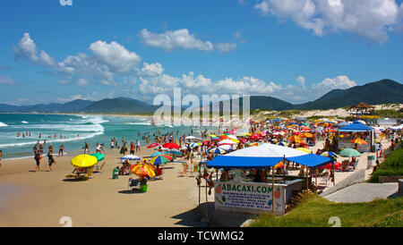 JOAQUINA BEACH, FLORIANOPOLIS, SANTA CATARINA, BRAZIL - MARCH 22, 2009: Many colorfull sunshades at the beach. People relaxing and enjoying the sun. Stock Photo