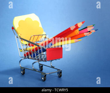trolley with school equipment on blue background Stock Photo